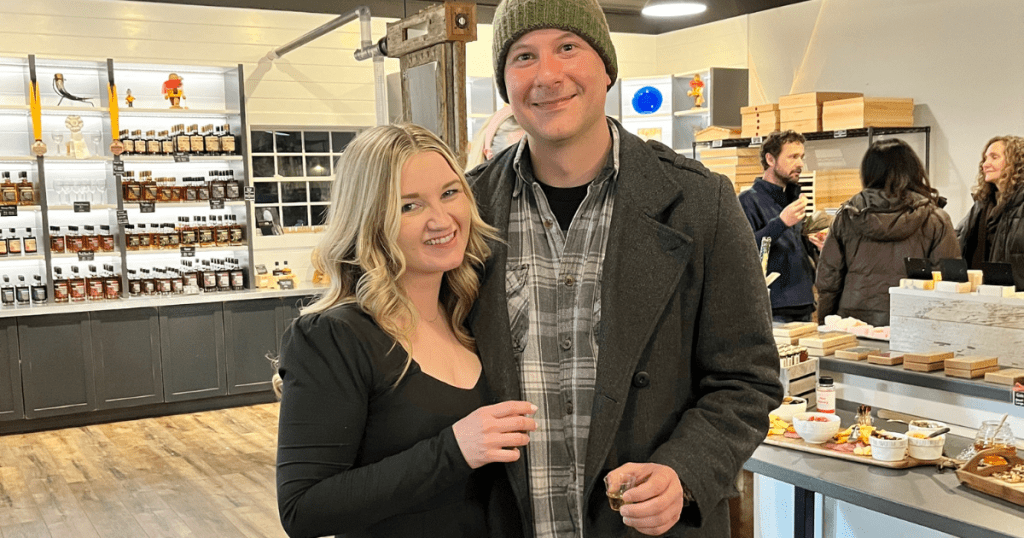 young couple smiling as they enjoy sampling different flavors of mead on their Guided Tour of a Local Meadery with Keolis massAdventures