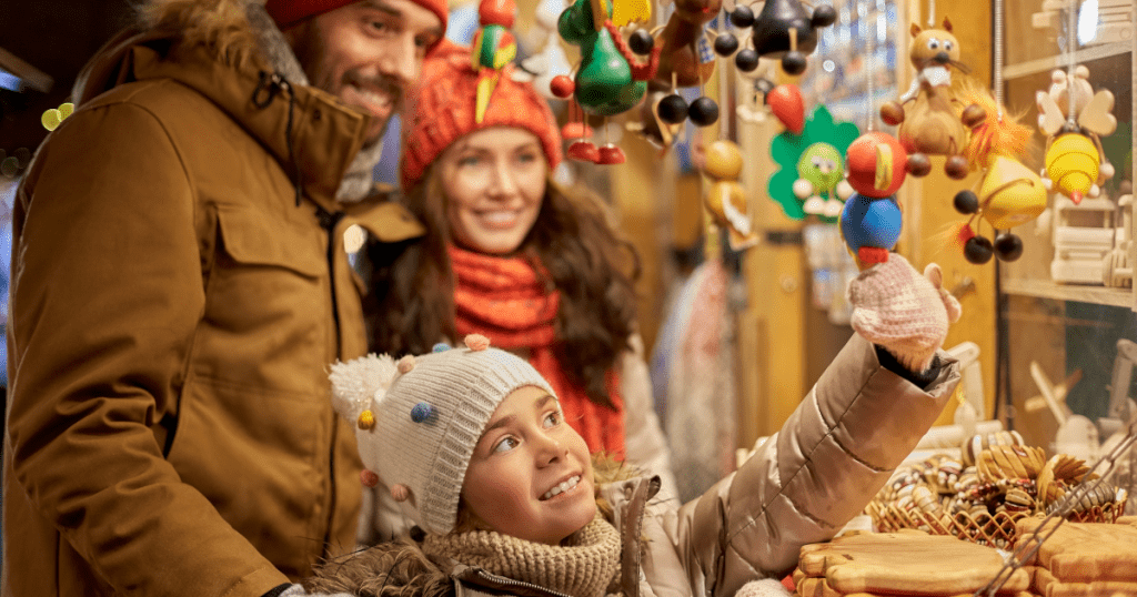 Child admiring a wooden toy at a holiday market in Boston