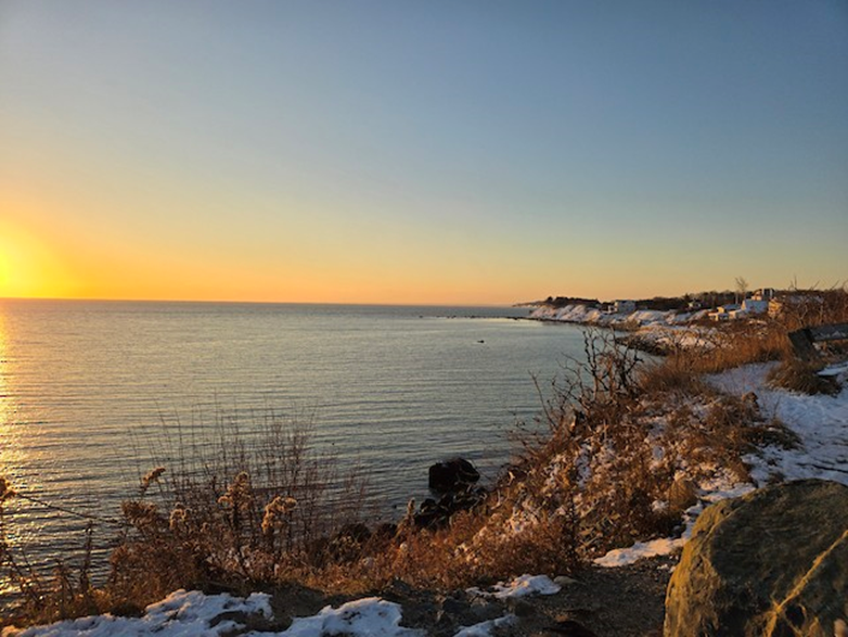 "Manoment Beach in Plymouth, MA at sunset with views of snow covered shorelines