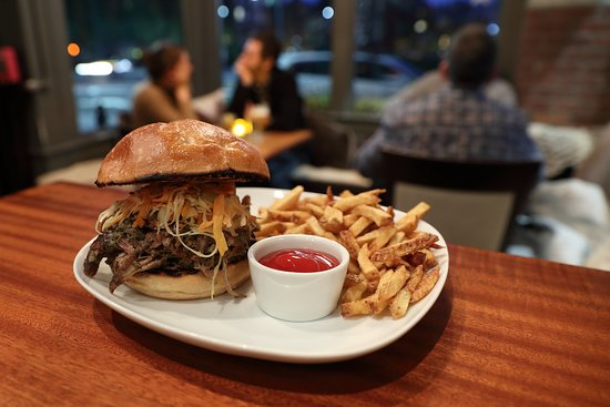 A burger on a plate with French fries from Armsby Abbey Restaurant, accessible via Worcester Station.