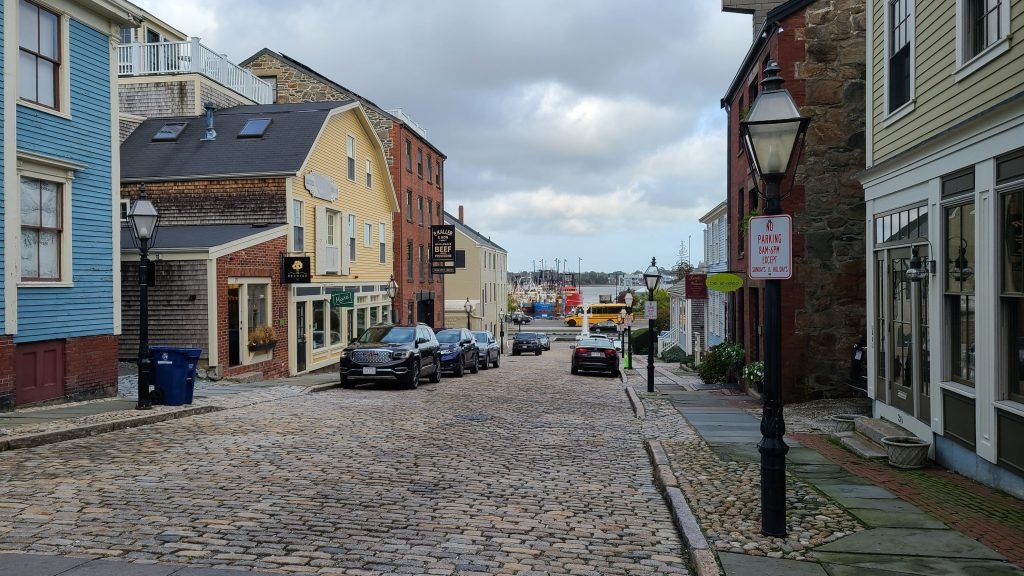 view of cobblestone street with the harbor in downtown New Bedford, MA