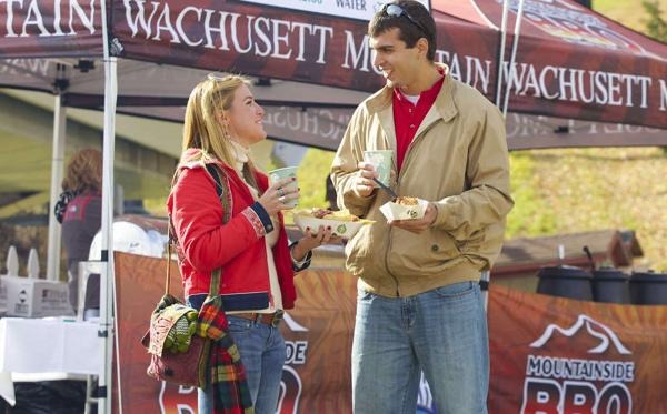 A couple enjoying food outdoors during a fall festival at Wachusett Mountain.